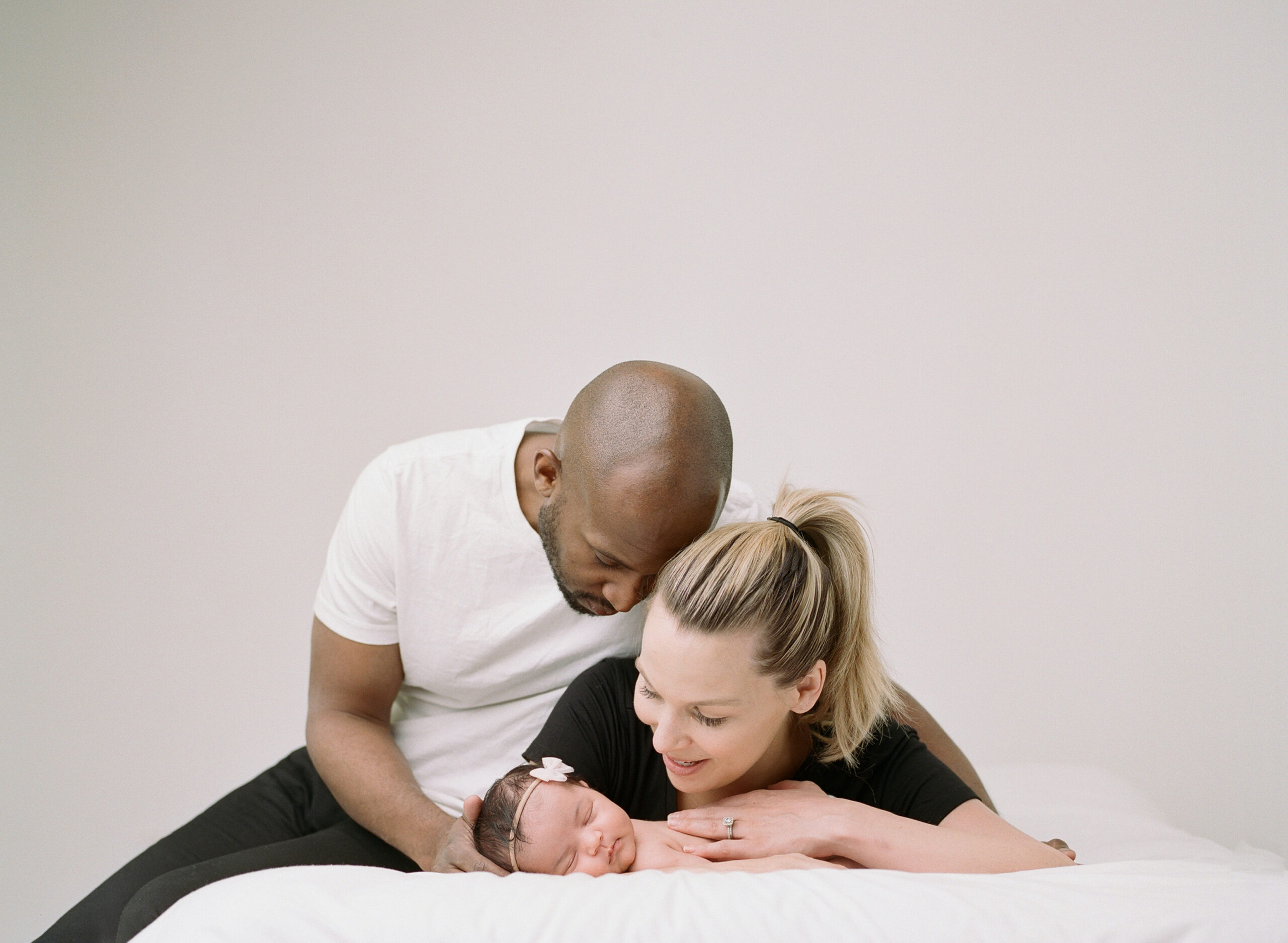 Family photo. Sleeping newborn in their parents arms.